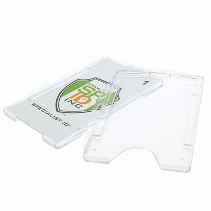 A Crystal Clear Rigid Open-Faced Single ID Card Holder (P/N SPID-075) with a partially visible card featuring a green and orange logo and the text “Specialist ID”. The holder, made from durable polycarbonate material, is open, showing its front and back parts along with adaptable slot holes for versatile attachment options.
