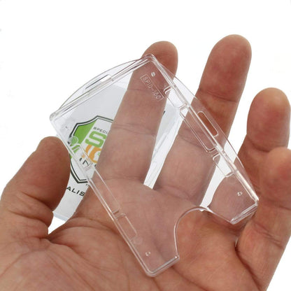 A hand holds a small, transparent Crystal Clear Rigid Open-Faced 2 Card Holder - Optional Vertical or Horizontal (P/N SPID-150) with some text and a partially visible logo in the background.