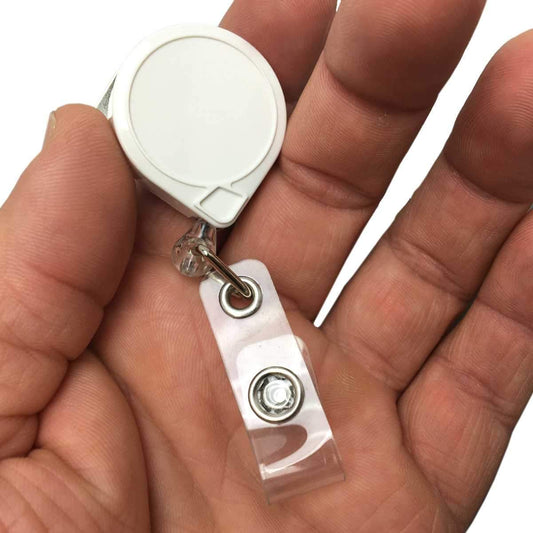 A hand holding a MINI-BAK #66 White Retractable Reel with 36” Nylon Cord, Vinyl ID Strap and Swivel Clip 0066-005, featuring a durable nylon cord.