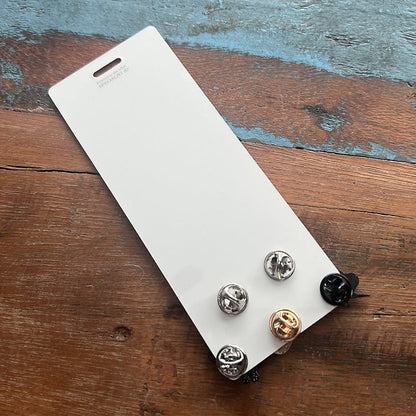 A white Pin Buddy for Displaying Pins with Badge Buddies - Vertical featuring 5 enamel pins of different colors and designs placed on a wooden surface. Sold by Specialist ID.