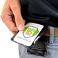 Close-up of a person holding a Specialist ID badge with a green and orange logo, attached to a Magnetic Vertical Double Pocket Badge Holder (1835-1115) on their belt. The person is wearing blue pants and a black shirt.