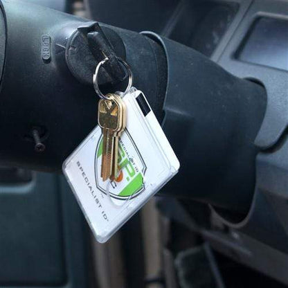 A set of keys with a Two Card Vertical Clear Rigid Plastic Fuel Card and Badge Holder with Keychain (SPID-1220) are inserted into the ignition of a vehicle.