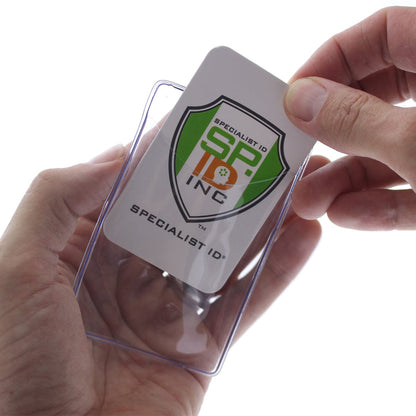 A person inserts a Specialist ID card into a Clear Plastic Luggage Identification Tag with Loops Included - Business Card or Photo Insert (Easy Access). The reusable protective pouch showcases a logo with "SP ID INC" and "Specialist ID" text, ensuring durability and longevity.