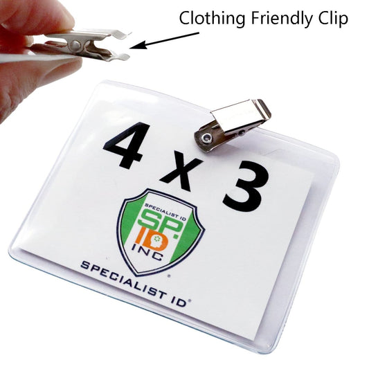 A close-up of a hand holding a 4 x 3 Horizontal Event Badge Holder with Clothing Friendly Bulldog Clip - Clear Vinyl, Horizontal & Durable (SPID-1440) attached to a clear vinyl name badge holder from Specialist ID.