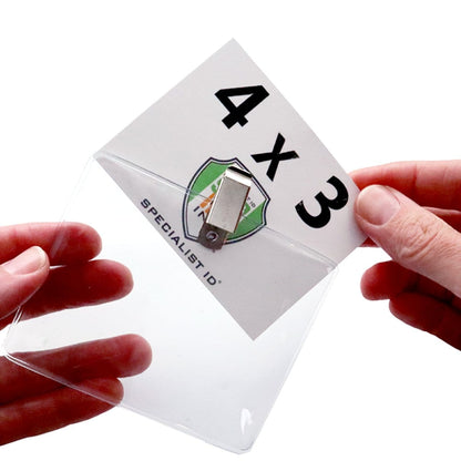 Two hands hold a 4 x 3 Horizontal Event Badge Holder with Clothing Friendly Bulldog Clip - Clear Vinyl, Horizontal & Durable (SPID-1440) fitting a card labeled "4 X 3" and displaying a logo.