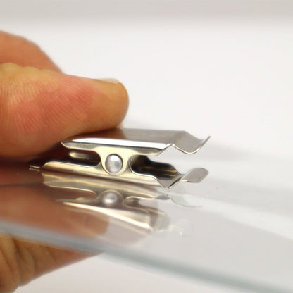 A close-up of a hand holding a 4 x 3 Horizontal Event Badge Holder with Clothing Friendly Bulldog Clip - Clear Vinyl, Horizontal & Durable (SPID-1440) attached to the edge of a clear vinyl name badge holder.