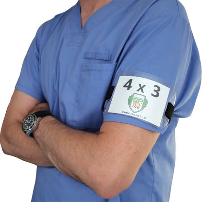A person wearing blue scrubs with an Armband Badge Holder Horizontal - 4" X 3" Name Badge Holder with Adjustable Arm Band on their arm and a watch on their left wrist. The arms are crossed.