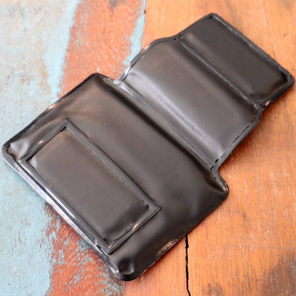 A Horizontal Magnetic Badge Holder (P/N 1835-1050) laying open on a wooden surface, showcasing various compartments and a clear vinyl front.
