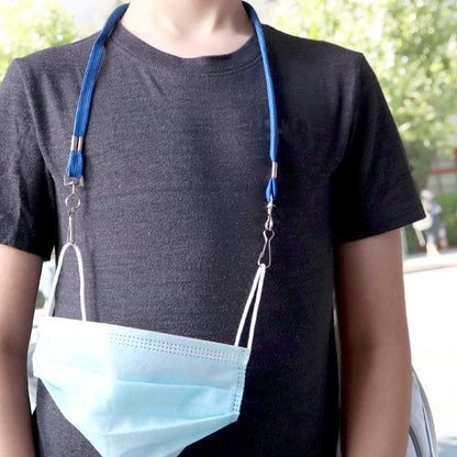 A person wearing a black t-shirt with a light blue face mask hanging from Kids Safe Double Ended Lanyards with Safety Breakaway Clasp and Two Hook Endings - Short Length for Children around their neck. Trees are visible in the background.
