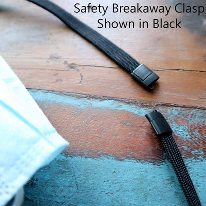 A black safety breakaway clasp attached to a black strap is displayed on a wooden surface, with the text "Kids Safe Double Ended Lanyards with Safety Breakaway Clasp and Two Hook Endings - Short Length for Children Shown in Black" in the top right corner. Perfect for use as a kids lanyard, ensuring maximum safety and convenience.