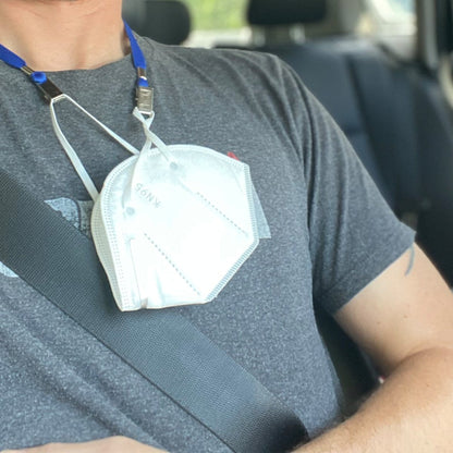 A person wearing a gray t-shirt with a white mask hanging from a 5 Pack Double Ended Lanyards with Bulldog Clips - Comfortable Premium Economy Neck Strap Badge Holder for Events is seated in a vehicle.