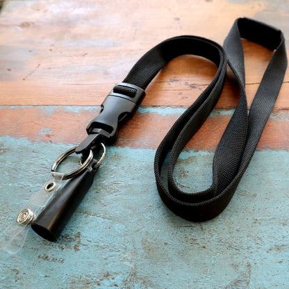A Lanyard with Pen and ID Badge Holder - All in One Neck Lanyards (SPID-2380) rests on a textured blue and brown surface. Sold by Specialist ID.