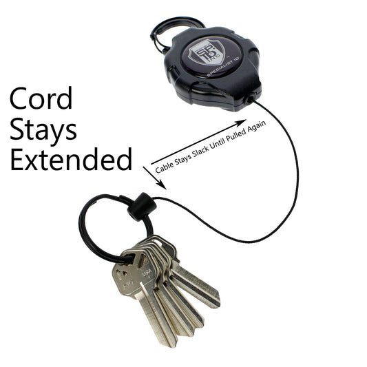 A Heavy Duty Retractable Ratchit Keychain Tether Reel for Multiple Keys with Clip and Locking Feature with a black case and extended Kevlar cord holding a set of five keys. Text reads: "Cord Stays Extended" and "Cable Stays Slack Until Pulled Again.