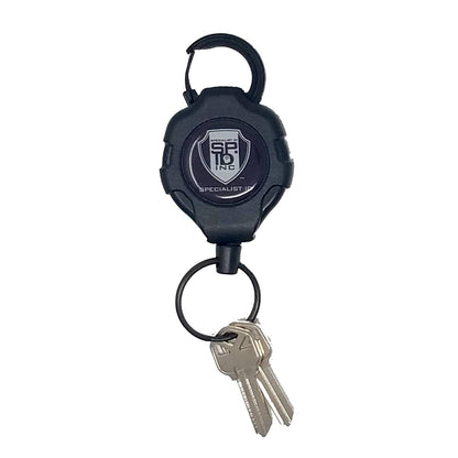 A black retractable key holder with a metal loop, attached to two silver keys, featuring a logo for "SF19 Inc Specialist ID." This Heavy Duty Retractable Ratchit Keychain Tether Reel for Multiple Keys with Clip and Locking Feature is designed with durability in mind.