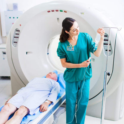 A healthcare worker, wearing an MRI Safe Badge Reel - Non-Ferrous Metal Retractable Badge Clips with No Twist ID Holder Clip for Imaging Room Techs & Nurses, adjusts an IV drip for a patient lying on a CT scanner bed in a medical facility.