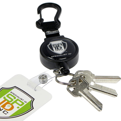 A Heavy Duty SPID Key-Bak Mid-Size Carabiner Retractable Badge Reel with Card Strap & Key Ring (SPID-3330) with a black Key-Bak badge reel, attached clip, and three keys. An ID badge with a "Specialist ID" logo is also attached, complemented by a durable Kevlar cord for added strength.