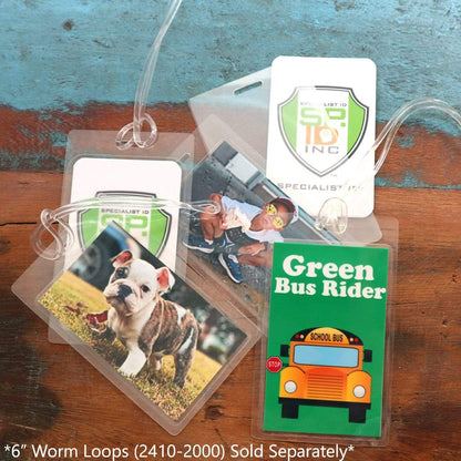Three ID badge holders are displayed on a table with six-inch worm loops. One holder, enclosed in a 10 Mil Heavy Duty Laminating Pouch for 2.5" x 4.25" Luggage Tags or ID with Vertical Slot Hole, has a green "Green Bus Rider" card; another has a photo of a bulldog puppy; and the last has an image of a child.