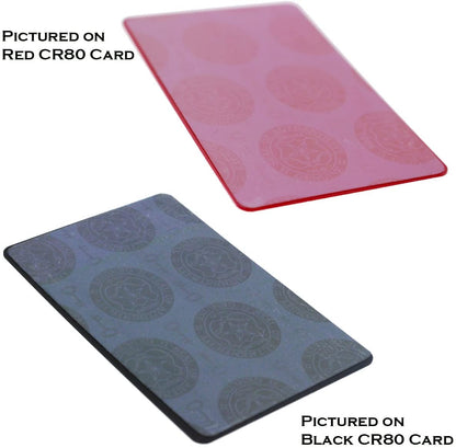 Two cards are shown: a red CR80 card at the top labeled "Pictured on Red CR80 Card" and a black CR80 card at the bottom labeled "Pictured on Black CR80 Card", both featuring a circular pattern. Each card includes a Self Adhesive Holographic Overlay - Shield and Key for added anti-counterfeiting protection.