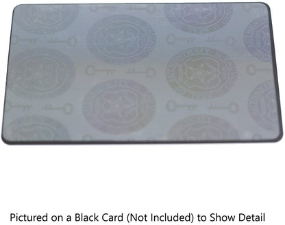 A rectangular card with a Self Adhesive Holographic Overlay - Shield and Key showcasing keys and circular emblems. The text in the image notes that it's pictured on a black card, which is not included, to show detail. This design offers anti-counterfeiting protection and serves as a Seal of Authenticity for your items.