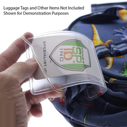 A hand holding a Clear Plastic Luggage Loop Straps 6 Inch - Durable Worm Loops (2410-2000) inserted with an informational card. A dinosaur-themed backpack appears in the background. Text above reads "Luggage Tags and Other Items Not Included Shown for Demonstration Purposes." Durable worm loops provide extra security and convenience.
