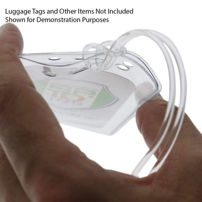 Close-up of a hand holding a clear plastic luggage loop with a card inside. Text reads: "Luggage Tags and Other Items Not Included. Shown for Demonstration Purposes." Features 6" Plastic Luggage Tag Loop Straps in Solid Colors - Red, Green, Black, Blue & White (2410-200X) perfect for secure attachment.