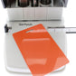A 3-in-1 ID Card Slot Punch w/ 1 hole Punch and Corner Rounder with an adjustable guide and ruler is shown. An orange plastic ID card with a punched slot is placed on the machine's surface.