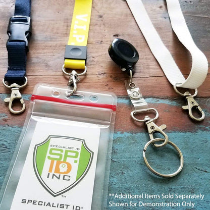 Four Premium Metal Lobster Claw Clasps with Wide ¾ Inch D Ring and 360 Swivel Snap Clasp Trigger ID / Key Clip (6920-2360) with various attachments, including a swivel snap hook and a badge holder, rest on a wooden surface. One clasp is black, another is yellow labeled "V.I.P.," and the others are white and blue. Badge reads "Specialist ID Inc." Perfect for anyone into lanyard making or needing reliable holders.