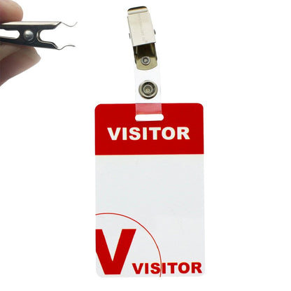 A red and white Reusable Visitor Passes with Clothing Friendly Badge Clip is shown against a plain background. A hand holding a staple remover is positioned near the badge.
