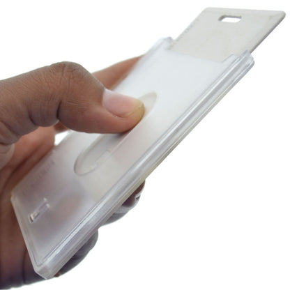 A hand holds a white Horizontal 70 - 90 Mil ProxCard II / Thick HID Proximity Card Holder (SPID-PROX-H) with a thumb pressing on its surface. The card holder has a slot for attaching to a lanyard or clip.