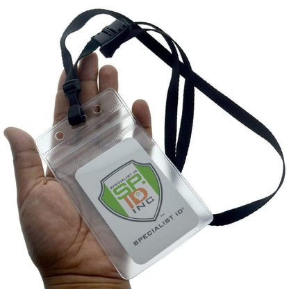 A hand is holding a Clear Vertical Vinyl Badge Holder with Zipper (506-ZS-CLR) with a black lanyard attached. The ID badge displays a logo with the text "Specialist ID Inc.