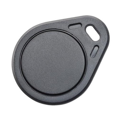 A close-up of a black, circular SPIDProx HID Compatible Key Fob utilizing radio frequency technology, with a hole for attaching to a keyring. Sold by Specialist ID.