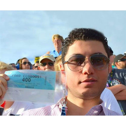 Man wearing sunglasses holds a ticket for the Ford EcoBoost 400 in a Vertical Oversized 4X7 Vinyl ID Badge & Ticket Holder (XL47.5V) at an outdoor event, with a crowd of people in the background.