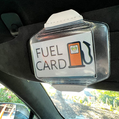 A Clear Fuel Card Holder for Visor with Elastic Band is attached to a car sun visor using an elastic band. The card displays an image of a fuel pump. Sold by Specialist ID.