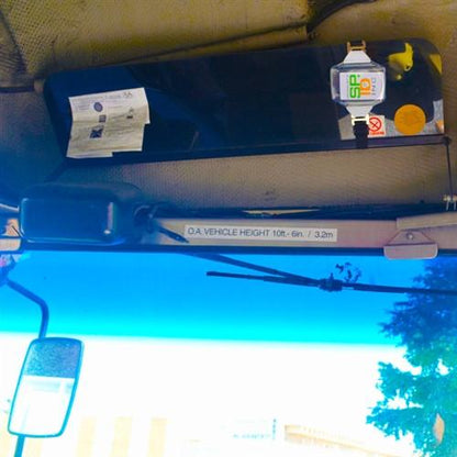 Interior view of a vehicle, showing a mirror, a Clear Fuel Card Holder for Visor with Elastic Band holding papers, and a mounted electronic device. A sticker indicates the vehicle height as "O.A. Vehicle Height 10 ft. 6 in. / 3.2m."
